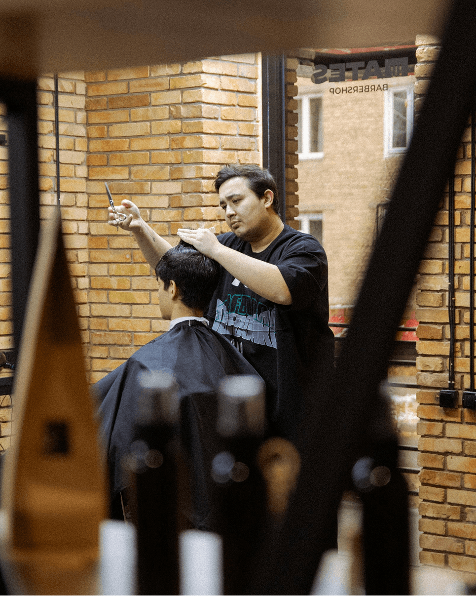 Barber styling a guest's hair at the Alpirious salon